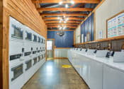 Thumbnail 19 of 28 - a laundry room with lots of white appliances and a long row of sinks