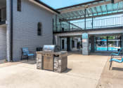 Thumbnail 6 of 8 - a patio with a grill and a building with a pool