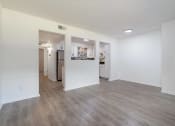 Thumbnail 2 of 8 - an empty living room and kitchen with white walls and wood flooring