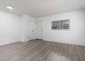 Thumbnail 3 of 8 - the living room of an apartment with white walls and wood flooring