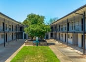 Thumbnail 8 of 8 - the courtyard of an apartment building with a tree in the center