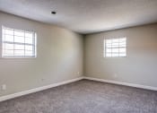 Thumbnail 12 of 16 - an empty bedroom with two windows and carpeting