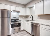 Thumbnail 5 of 16 - a kitchen with white cabinets and stainless steel appliances