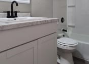Thumbnail 15 of 16 - a white bathroom with a sink and a toilet