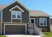 Thumbnail 2 of 25 - a brown house with a garage door