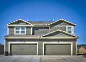Thumbnail 2 of 14 - a house with a garage door in front of it