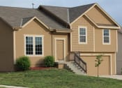 Thumbnail 3 of 21 - a brown house with a front porch and a yard
