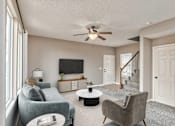 Thumbnail 3 of 14 - a living room with couches and a ceiling fan