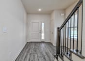 Thumbnail 28 of 32 - A hallway with a wooden floor and a black railing.