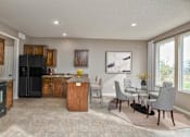 Thumbnail 4 of 14 - a kitchen and dining room with a table and chairs and a refrigerator