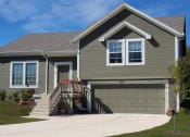 Thumbnail 5 of 25 - a house with a driveway and a garage door