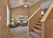 Thumbnail 5 of 21 - a living room with stairs and a ceiling fan
