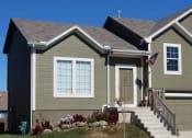 Thumbnail 6 of 25 - a green house with a flag in front of it