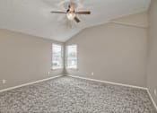 Thumbnail 7 of 14 - an empty living room with a ceiling fan and a window