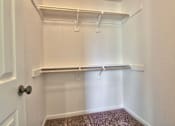 Thumbnail 10 of 14 - a walk in closet with a hanging rail and white walls