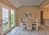 Thumbnail 11 of 21 - a dining room with a table and chairs and a sliding glass door