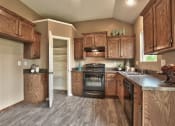 Thumbnail 14 of 21 - a kitchen with wooden cabinets and a stove and a sink