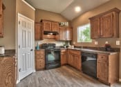 Thumbnail 15 of 21 - a kitchen with wooden cabinets and black appliances