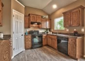 Thumbnail 18 of 25 - a kitchen with wooden cabinets and black appliances