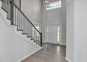 Thumbnail 5 of 52 - A white interior with a staircase and a chandelier.