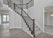 Thumbnail 6 of 52 - A staircase with a wooden handrail and a light fixture above it.