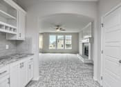 Thumbnail 8 of 52 - A spacious kitchen with white cabinets and a marble countertop.