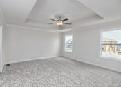 Thumbnail 15 of 52 - A spacious room with a ceiling fan and carpeted floor.