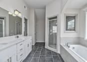 Thumbnail 17 of 52 - A bathroom with a white tub and sink.