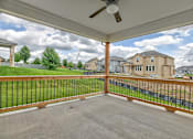 Thumbnail 4 of 52 - A patio with a black railing and a ceiling fan.