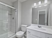 Thumbnail 19 of 52 - A white bathroom with a toilet, sink, and shower.