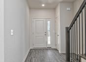 Thumbnail 29 of 32 - A hallway with a white door and a black railing.