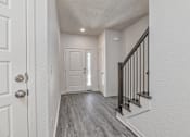 Thumbnail 4 of 32 - A hallway with a white door and a black railing.