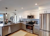 Thumbnail 15 of 32 - a kitchen with white cabinets and stainless steel appliances