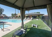 Thumbnail 3 of 36 - a backyard with a pool and a patio with chairs and a table