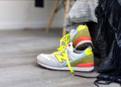 Thumbnail 11 of 33 - a close up of a person laying on the floor wearing a pair of sneakers