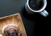 Thumbnail 33 of 33 - a doughnut sitting on top of a wooden cutting board next to a cup of coffee