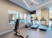 Thumbnail 26 of 32 - A spacious gym with treadmills, elliptical machines, and other exercise equipment.