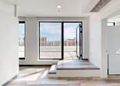 Thumbnail 17 of 32 - A modern room with a view of the city through the windows.