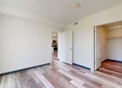 Thumbnail 11 of 32 - A room with a white wall and a wooden floor.
