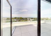 Thumbnail 31 of 32 - A view from a window looking out at a cityscape.