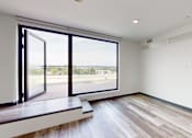 Thumbnail 15 of 32 - A room with a large window overlooking a street.