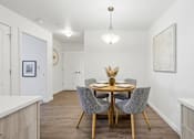 Thumbnail 12 of 38 - A dining room with a round table and grey chairs.