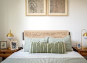 Thumbnail 11 of 30 - The Wes Gresham Oregon Apartments bedroom with A bed with green striped pillows and a wooden headboard.