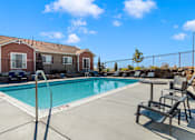 Thumbnail 38 of 38 - A pool with a diving board and a building in the background.