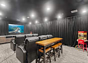 Thumbnail 17 of 33 - A black and white photo of a home theater with a wooden table and chairs.