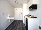 Thumbnail 15 of 33 - a small kitchen with white cabinets and black appliances