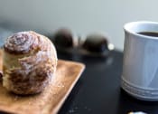 Thumbnail 14 of 33 - a doughnut on a cutting board next to a cup of coffee