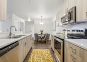 Thumbnail 20 of 38 - A modern kitchen with wooden cabinets and a yellow rug on the floor.