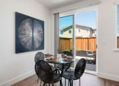 Thumbnail 15 of 30 - a dining room with a table and chairs and a sliding glass door