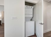 Thumbnail 24 of 30 - a white washer and dryer in a room with a door